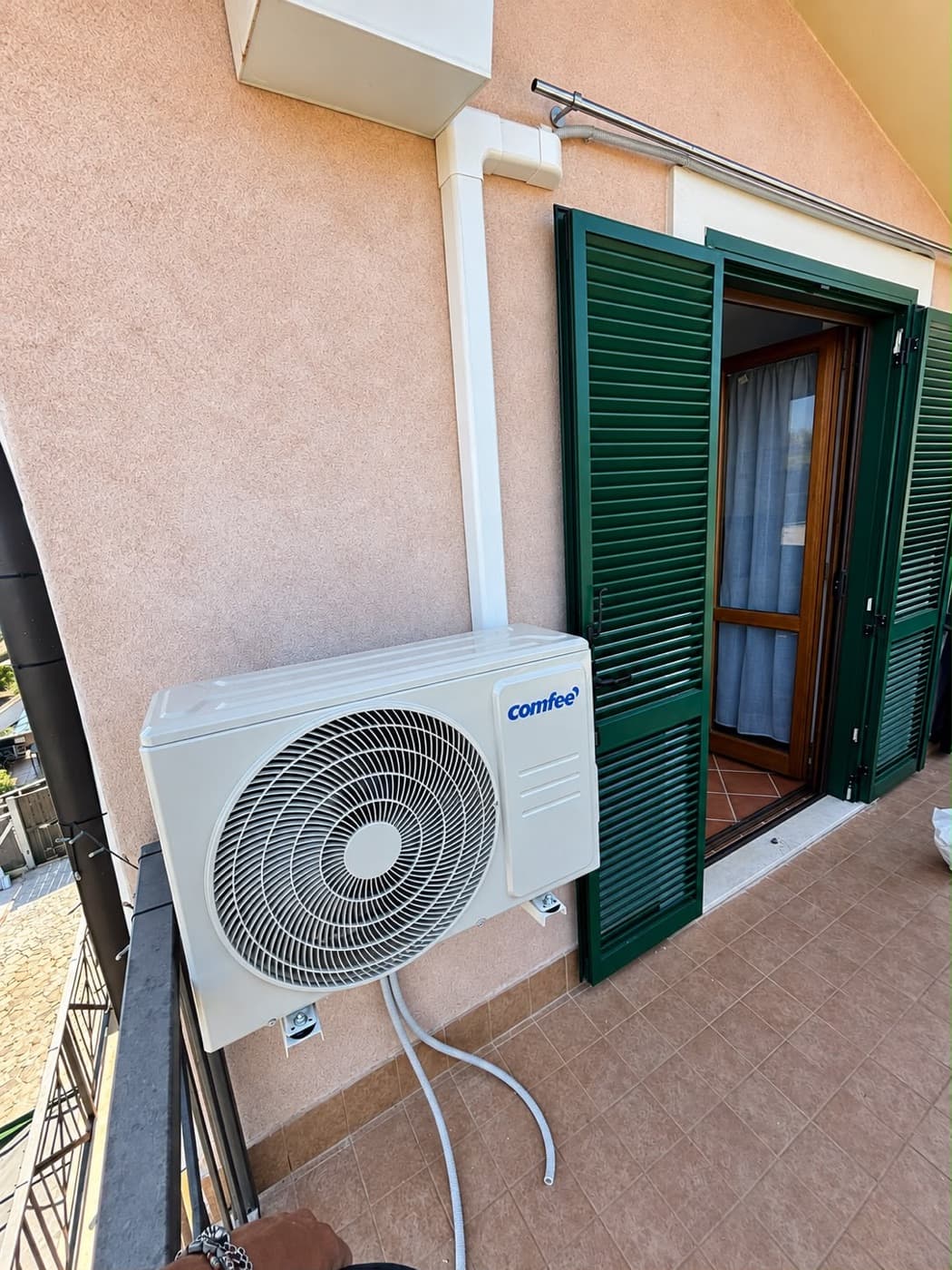 Unità esterna Comfee installata su balcone con canalina bianca